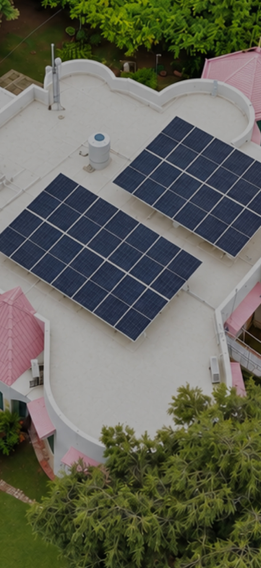 Aerial view of a residential rooftop solar installation surrounded by lush greenery